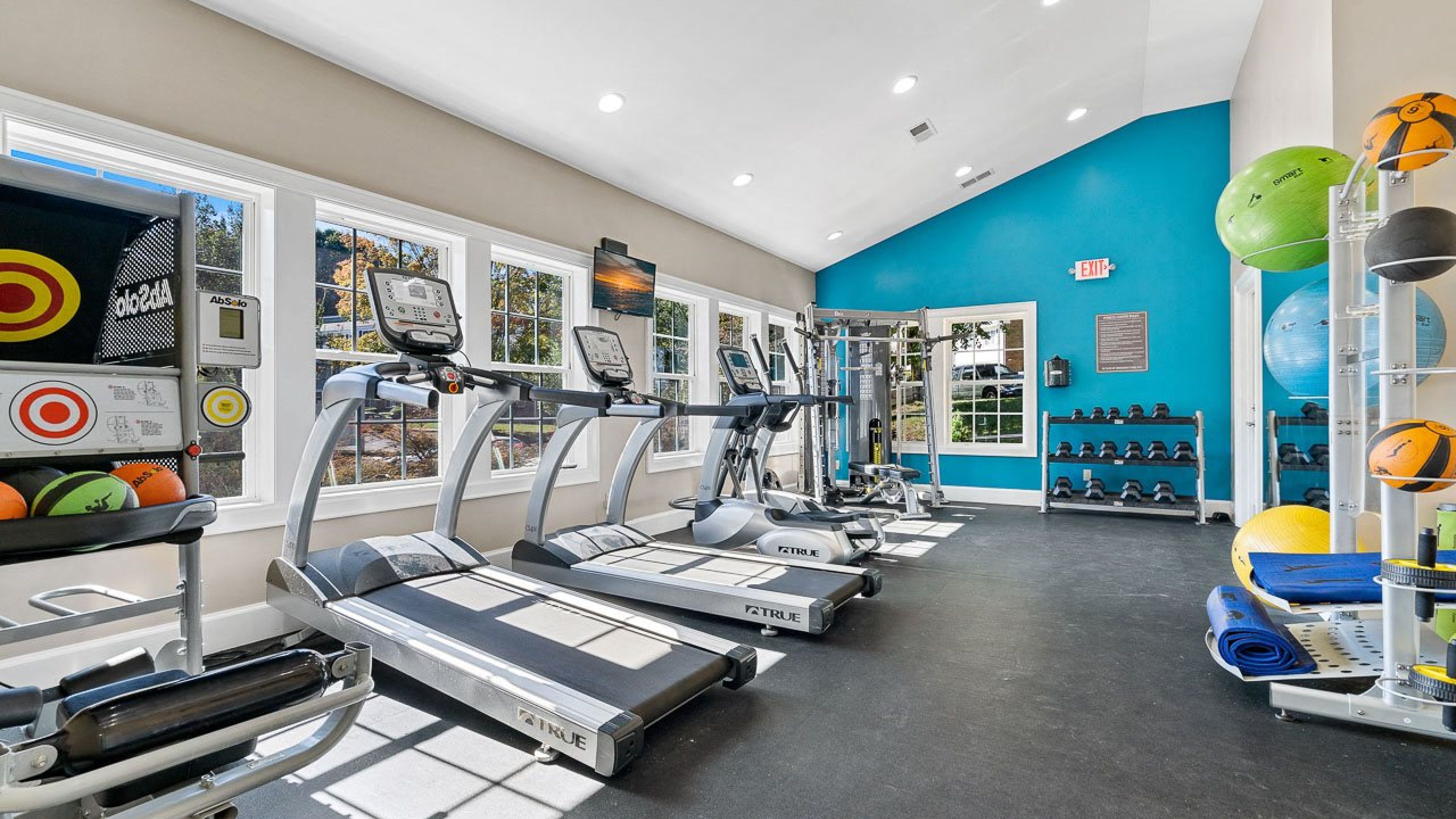 Hawthorne at Bear Creek community fitness center with cardio machines, free weights, and colorful fitness equipment.